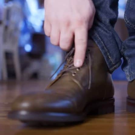 Man pointing to eyelet on boot he is wearing