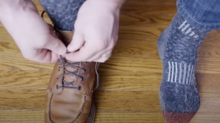 Close up of man putting on boots over thick socks